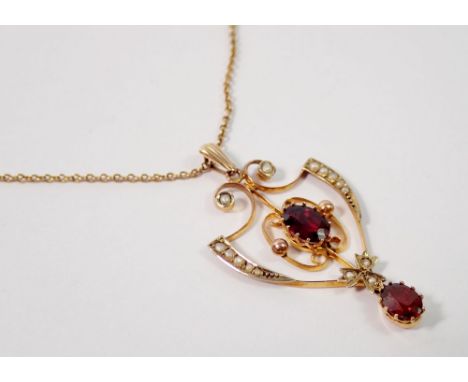 An Edwardian Art Nouveau openwork pendant set garnets and seed pearls, 4cm drop on 9 carat gold chain, 4.5g 