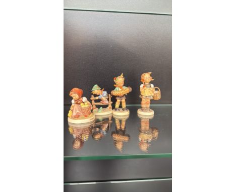 Set of four vintage Goebel Hummel figurines from West Germany. Hand-painted porcelain, featuring charming children in traditi