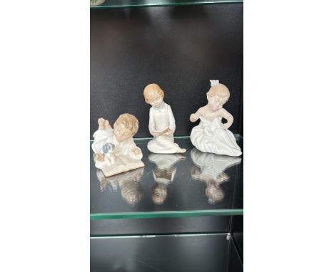 Set of three Nao by Lladro porcelain figurines, sculpted young children in soft pastel tones.