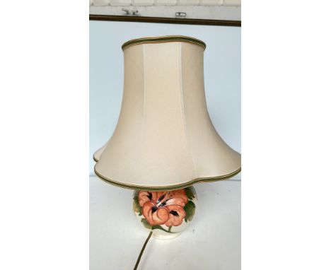 Moorcroft ceramic table lamp with vibrant hand-painted floral design, complemented by a cream fabric shade with green trim.