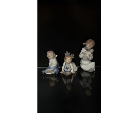 Set of three Nao by Lladró porcelain figurines, made in Spain. Finished in soft pastel tones with a glossy glaze