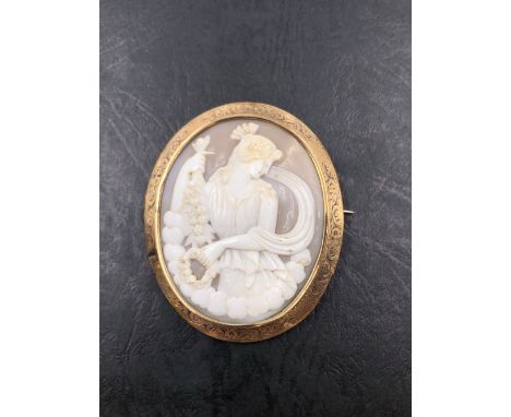 AN ANTIQUE OVAL PORTRAIT CAMEO OF A CLASSICAL MAIDEN FRAMED IN A FOLIATE CARVED BROOCH MOUNT. UNHALLMARKED ASSESSED AS 9ct GO