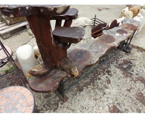 A WROUGHT IRON AND WOOD BENCH TOGETHER WITH A ROOT WOOD PLANT STAND