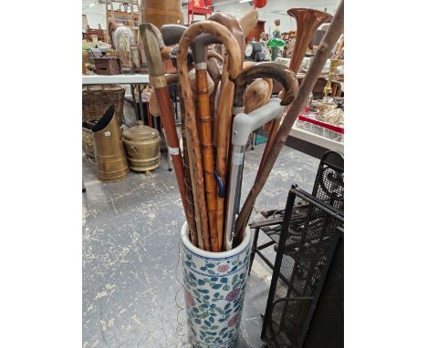 A QUANTITY OF WALKING STICKS IN A POTTERY STICK STAND