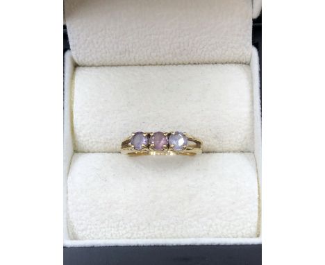 A THREE STONE GEMSET RING, UNHALLMARKED,ASSESSED AS 9ct GOLD. FINGER SIZE K 1/2. WEIGHT 2.49grms. 