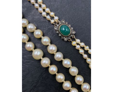 A VINTAGE DOUBLE ROW OF GRADUATED PEARLS. THE NECKLACE COMPLETED WITH A GREEN CABOCHON AND OLD CUT DIAMOND CLAP, THE CLASP UN