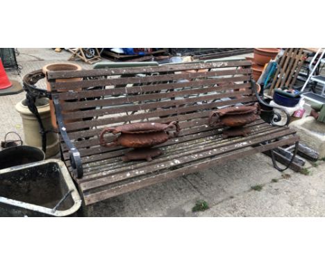 A LARGE GARDEN BENCH WITH BLACK PAINTED IRON SUPPORTS