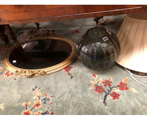 A LARGE GLASS LAMP AND AN OVAL GILT FRAMED WALL MIRROR