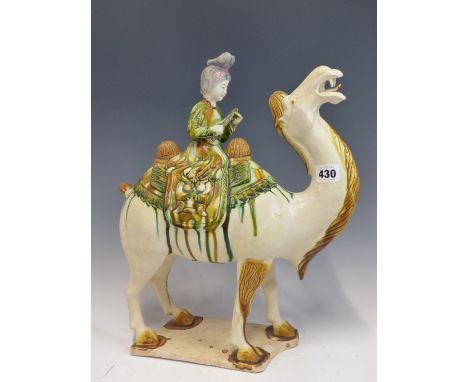 A TANG STYLE CAMEL RIDDEN BY A LADY PLAYING A FLUTE.  H 41cms.