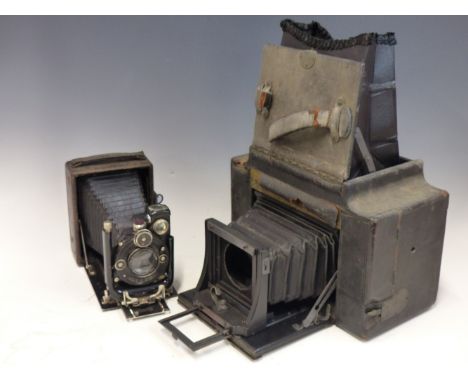 A HOUGHTONS LEATHERETTE CASED HALF PLATE CAMERA, A RULEX QUARTER PLATE CAMERA, A GRAFLEX CAMERA AND A LEATHER CASED BUSCH CAM