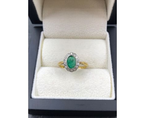 AN ANTIQUE 18ct AND PLATINUM STAMPED EMERALD AND DIAMOND OVAL CLUSTER RING. HEAD MEASUREMENTS 11.2 X 9.3mm. FINGER SIZE L 1/2