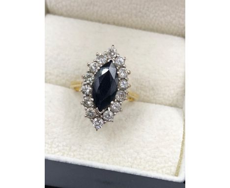 AN 18ct HALLMARKED GOLD MARQUISE CUT BLUE SAPPHIRE AND DIAMOND CLUSTER RING. THE SAPPHIRE MEASUREMENTS 12.2 X 5.2 X D 3.3mm, 