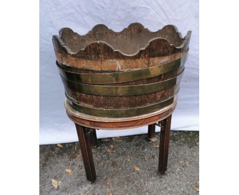 A Georgian mahogany brass bound wine cooler, of oval form in the style of a barrel with waved rim, on four straight moulded l