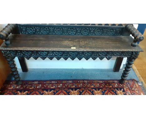 A Victorian oak carved window seat having bobbin turned arms and legs 24"h x 49"w A/F 