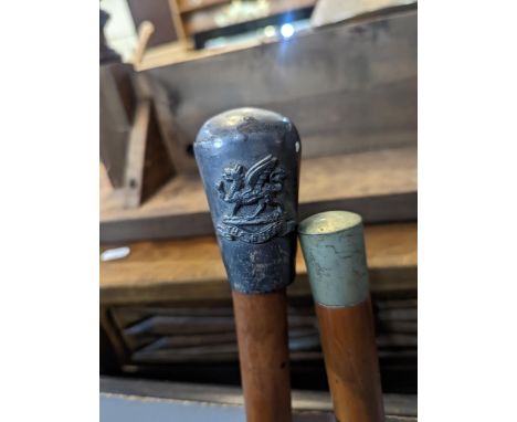 A pair of 'The Buffs' Royal East Kent Regiment swagger stick and a bamboo cane, one other swagger stick and a riding crop Loc