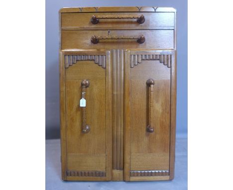 An Art Deco oak cabinet with two long drawers with horizontal handles above two cupboard doors with vertical handles, H.127 W