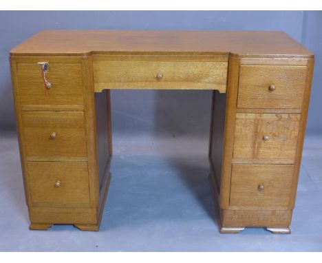 An Art Deco oak desk, with central long drawer flanked by six short drawers, on bracket feet, H.74 W.106 D.49cm 