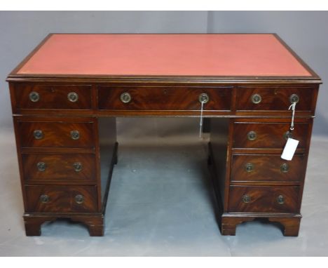 A Georgian style mahogany pedestal desk with an arrangement of nine drawers, H75cm, W123cm, D76cm