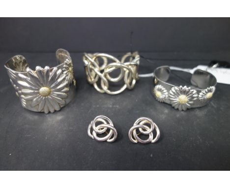 Two cuff bangles with daisies marked 925, together with a braided bangle and two earrings 