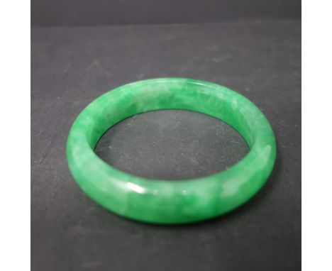 A Chinese green jadeite bangle, internal diameter 5.7cm 