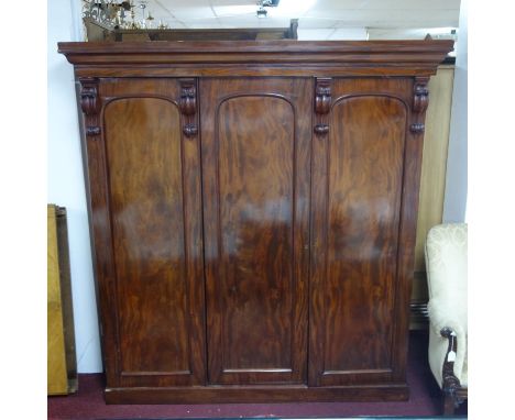 A large Victorian mahogany wardrobe, the moulded cornice above acanthus and scroll carvings, having three doors, with central