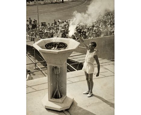 A period photograph of the athlete John Mark lighting the cauldron at the London 1948 Olympic Games,a 10 by 8in. b&w, framed 