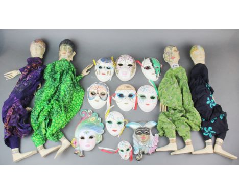 A group of four hand painted Indonesian wooden cloth puppets, size H. 60cms. together with a group of ceramic masks.