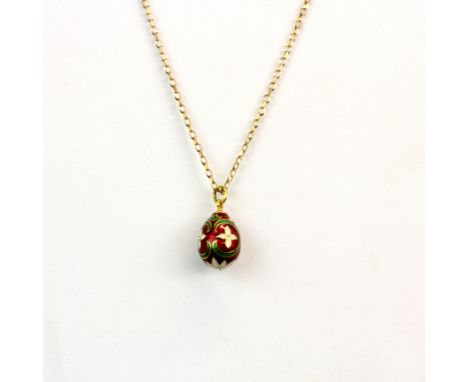 A 9ct gold chain with a yellow metal and enamel egg pendant (stamped AU) chain L. 47cm.