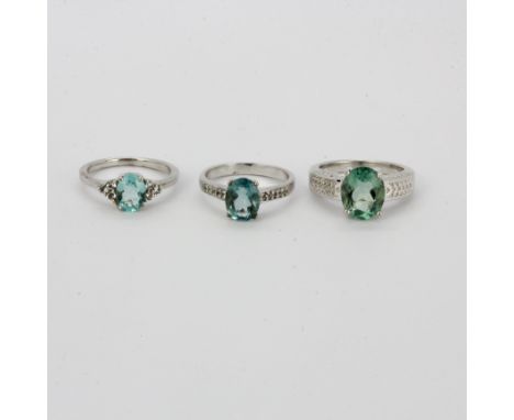 Two 925 silver rings set with oval cut green amethyst, one also with clear quartz shoulders. Together with a further similar 