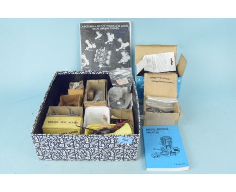 A box of mixed accessories and parts for various model aeroplane engines including an engine test stand, two boxes and air co