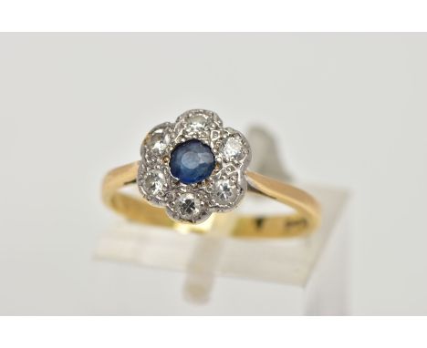 AN 18CT GOLD SAPPHIRE AND DIAMOND CLUSTER RING, of a flower shape, centring on a circular cut blue sapphire, within a surroun