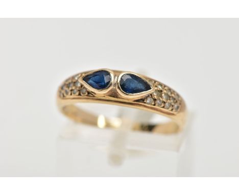 A 9CT GOLD SAPPHIRE AND DIAMOND RING, set with two pear cut blue sapphires, each collet mounted, flanked with single cut diam