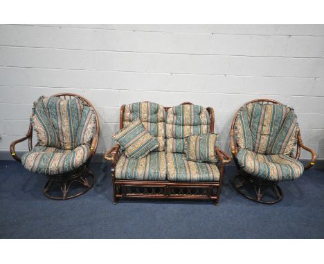 A WICKER CONSERVATORY SUITE, comprising a two seater sofa and a pair of egg swivel/reclining chairs (condition:-upholstery di