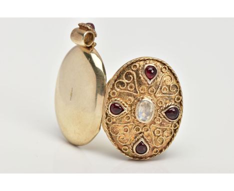 A SILVER GILT LOCKET PENDANT, of an oval form, set with a central oval cut moonstone, with red cabochons assessed as paste, a