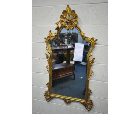 A FRENCH STYLE GILTWOOD WALL MIRROR, with acanthus leaves, flower heads below a still life surmount, 68cm x 130cm (condition: