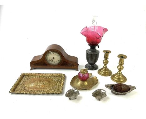 An Art Nouveau brass and cranberry glass ink stand, with silver plated oil lamp with cranberry glass shade, brass candlestick