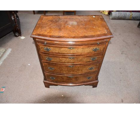 A 1950s burr walnut veneered bow front chest of drawers, with slide above four drawers, on bracket feet, width 70cm, depth 50