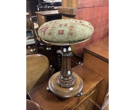 A 19th century carved mahogany piano stool with tapestry rotating top, height 49cm.