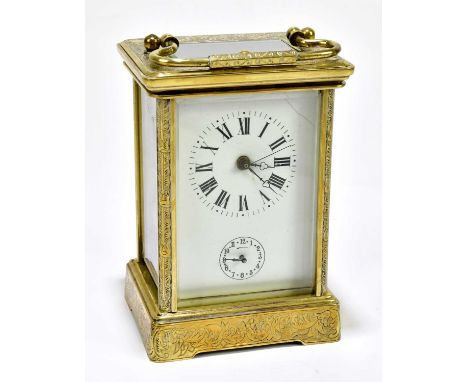 A brass repeating carriage clock with allover engraved detail and Roman numerals to the rectangular white enamel dial with su
