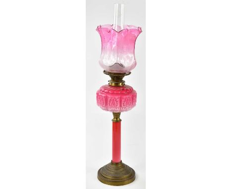 A late Victorian oil lamp, the cranberry and clear glass shade with panelled detail and etched floral decoration above the mo