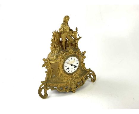 A late 19th/early 20th century gilt metal figural mantel clock with a farm hand above the enamelled dial set with Roman numer