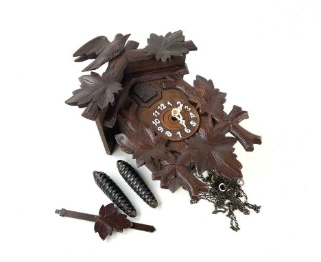 A carved 20th century cuckoo clock, decorated with leaves and bird, 32cm.