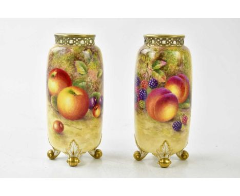 HARRY AYRTON FOR ROYAL WORCESTER; a pair of cylindrical vases with reticulated rims on four scrolling feet, each decorated wi