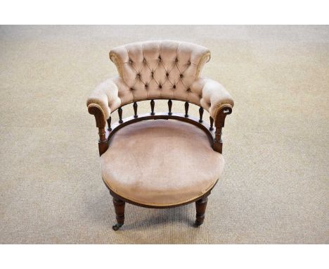 A Victorian walnut button back tub chair, raised on turned tapering legs terminating on castors.