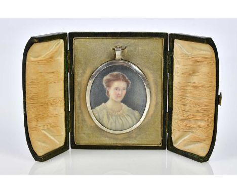 An early 20th century watercolour on ivory, portrait miniature of a girl wearing a white nightdress, signed 'M. N. McD' and d