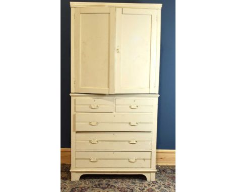 A white painted tallboy with pair of panelled doors enclosing three fixed shelves above the base section with two short over 