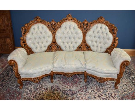 A large Victorian style three seat sofa with carved wooden frame, width approx 214cm (7ft).