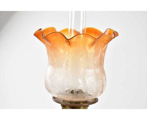 A late Victorian oil lamp, the orange tinted and clear glass shade with wavy rim and etched decoration above the moulded glas