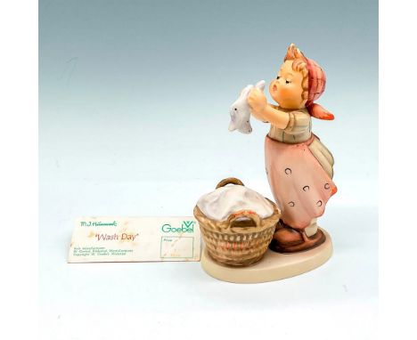 Little figural colored in blush with browns and whites, holding laundry with full basket on ground. Goebel backstamp. M.I. Hu