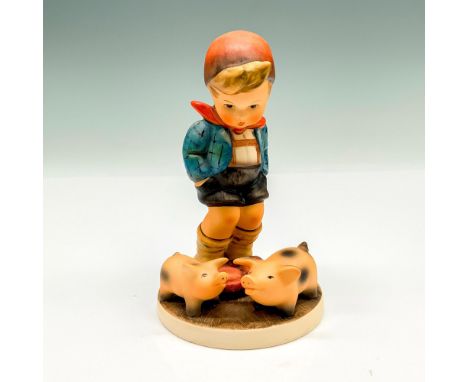 This figurine depicts a young boy with two pigs. It has the Goebel backstamp on the bottom. Item comes with its original box 